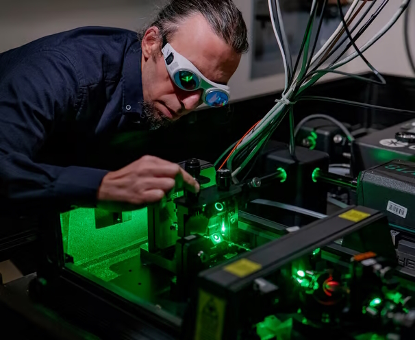 A scientist using a green laser in a laboratory